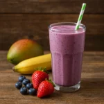 Sklenený pohár so smoothie na drevenom stole – zdravý nápoj s ovocím a bylinkami
